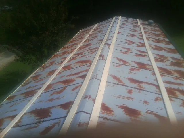 Rusted metal roof panels with new wood purlins before replacement — Storm Damage Roof Repair in Skull Valley by Roofing Brothers