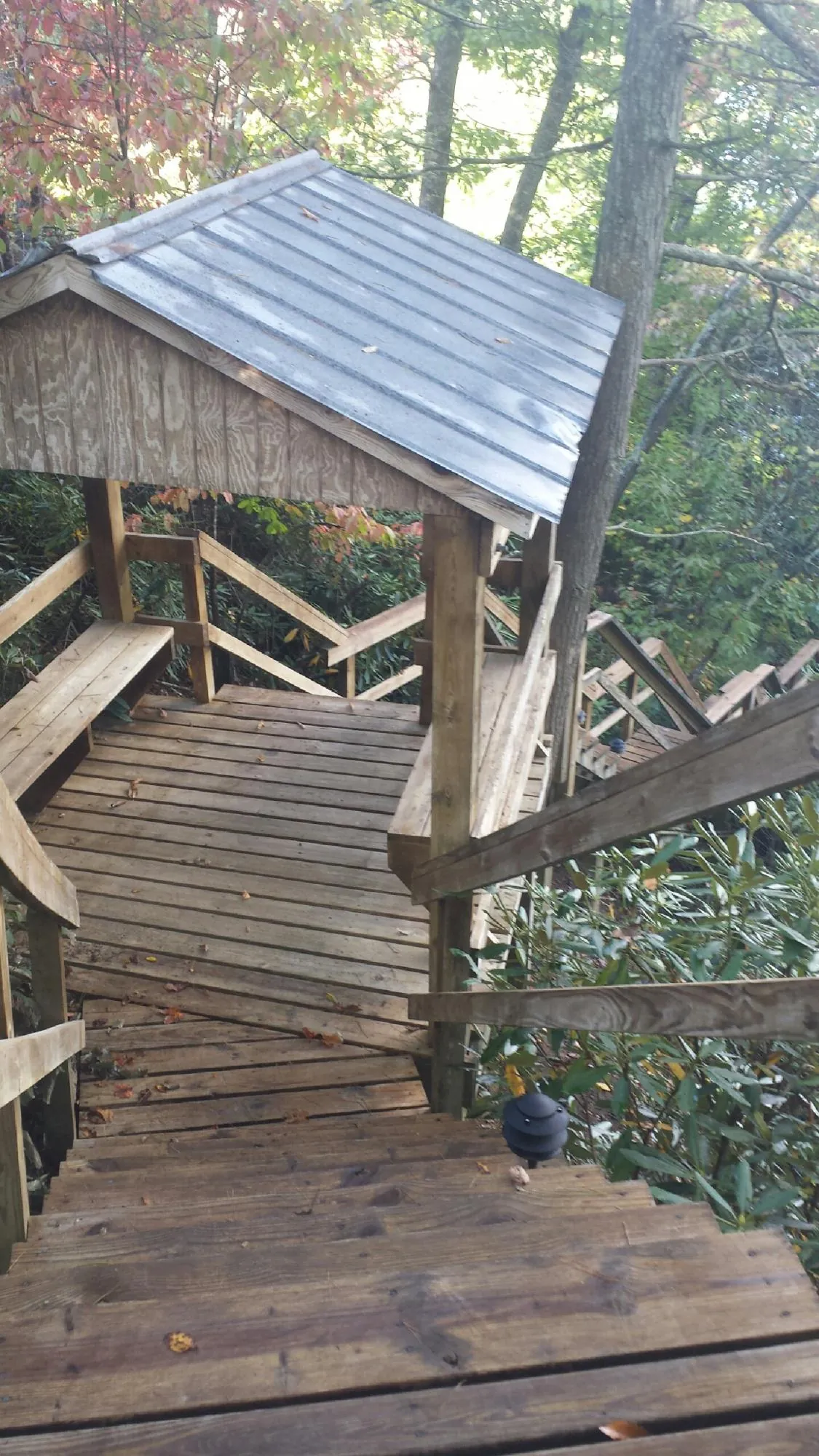 Metal roofed shelter over wooden steps on a wooded walkway — Skylight Repair & Installation work by our crew in Skull Valley
